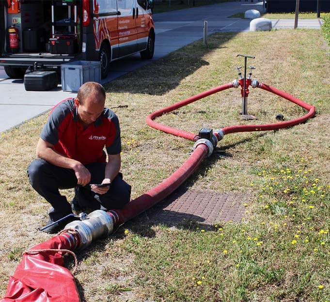 Medewerker Meis Brandbeveiliging met brandslang